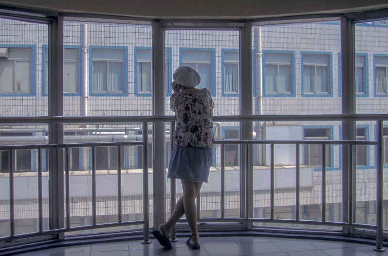 2011年7月6日,广东东莞,某电子厂的女工在楼梯的转角处发呆。