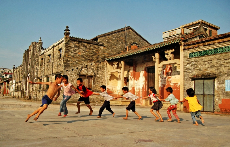 2007年10月6日,广东东莞,在出租屋外玩游戏的打工人的孩子们。